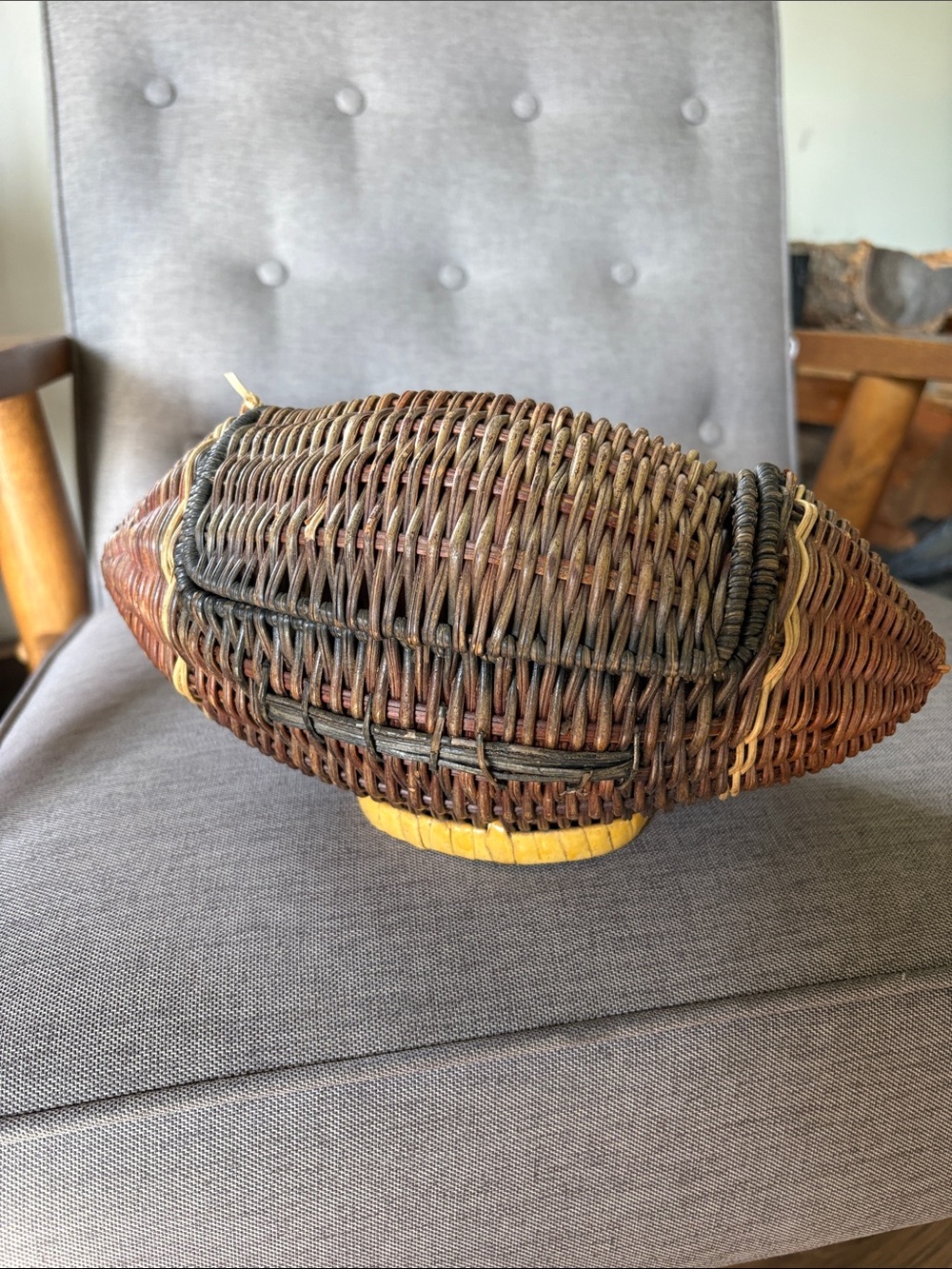 vintage, hand-woven wicker football-shaped basket with a hinged lid